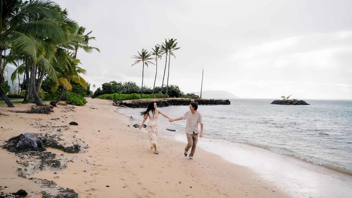Couple posing on a Honolulu beach at golden hour during a private vacation photoshoot in Hawaii